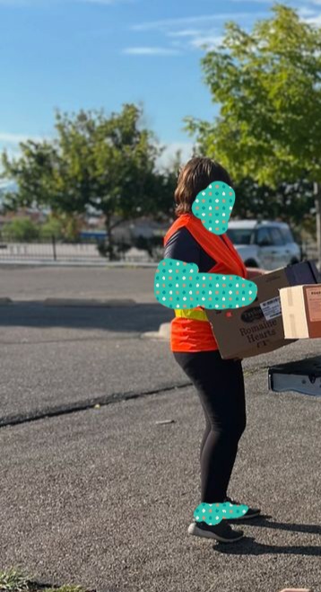 Volunteer carries box to load it in the tail of a truck.